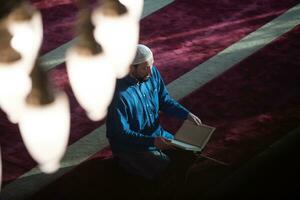 moslim Mens bidden Allah alleen binnen de moskee en lezing Islamitisch hulst boek foto