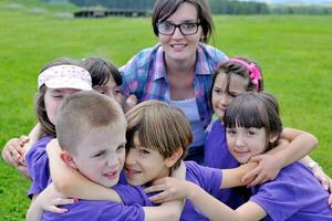 groep gelukkige kinderen met leraar in de natuur foto