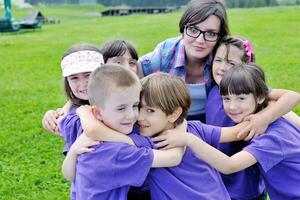 groep gelukkige kinderen met leraar in de natuur foto