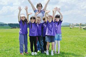 groep gelukkige kinderen met leraar in de natuur foto