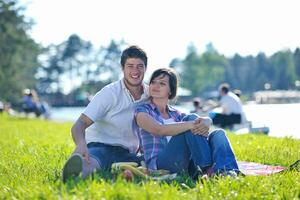 gelukkig jong paar hebben een picknick buitenshuis foto