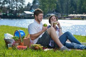 gelukkig jong paar hebben een picknick buitenshuis foto