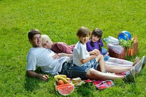 gelukkig familie spelen samen in een picknick buitenshuis foto