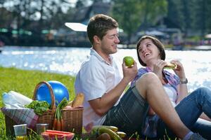 gelukkig jong paar hebben een picknick buitenshuis foto