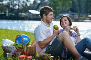 gelukkig jong paar hebben een picknick buitenshuis foto