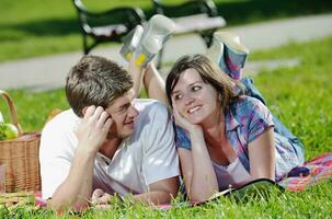 gelukkig jong paar hebben een picknick buitenshuis foto
