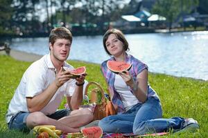 gelukkig jong paar hebben een picknick buitenshuis foto