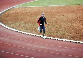 volwassen Mens rennen Aan atletiek bijhouden foto