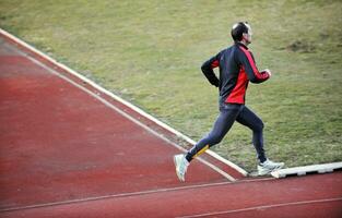 volwassen Mens rennen Aan atletiek bijhouden foto