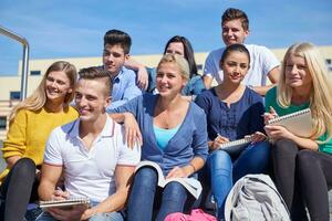 studenten buiten zittend Aan stappen foto