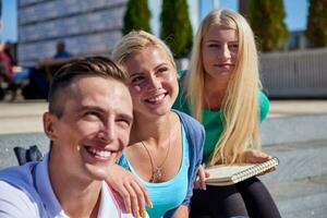 studenten buiten zittend Aan stappen foto