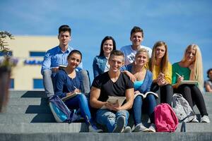 studenten buiten zittend Aan stappen foto