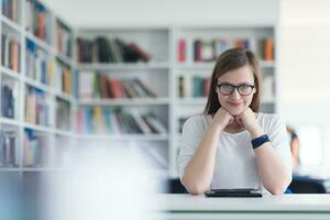 vrouw leerling studie in school- bibliotheek, gebruik makend van tablet foto