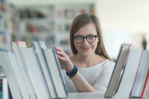 portret van famale leerling selecteren boek naar lezen in bibliotheek foto