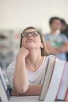 portret van famale leerling selecteren boek naar lezen in bibliotheek foto