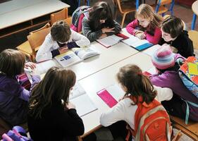 gelukkig kinderen met leraar in school- klas foto