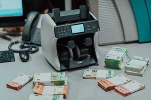 gesorteerd bankbiljetten geplaatst Aan de tafel na het is geteld Aan de elektronisch geld tellen machine foto