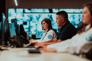 groep van veiligheid gegevens centrum operators werken in een cctv toezicht houden kamer op zoek Aan meerdere monitoren officieren toezicht houden meerdere schermen voor verdacht activiteiten team werken Aan de systeem controle foto