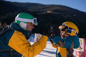 vader voorbereidingen treffen zijn weinig zoon voor de eerste tijd Aan een snowboard foto