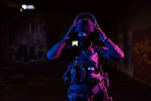 leger soldaat in gevecht uniformen met een aanval geweer- en gevecht helm nacht missie donker achtergrond. blauw en Purper gel licht effect. foto