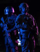modern oorlogvoering soldaten in donker met gevecht munitie en wapens in de handen van uitgerust laser bezienswaardigheden zijn in strijd bestellen. gemengd media. foto