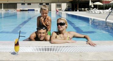 gelukkig jong familie hebben pret Aan zwemmen zwembad foto