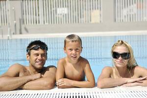 gelukkig jong familie hebben pret Aan zwemmen zwembad foto