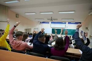 verheven handen en armen van groot groep van mensen in klasse kamer foto