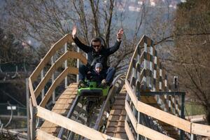 vader en zoon geniet het rijden Aan alpine kustvaarder foto