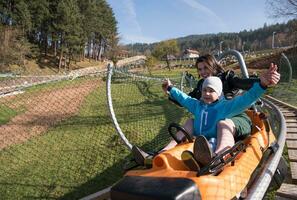 moeder en zoon geniet het rijden Aan alpine kustvaarder foto