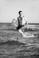 portret van een jong kitsurfen Mens Bij strand Aan zonsondergang foto