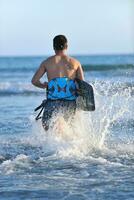 portret van een jong kitsurfen Mens Bij strand Aan zonsondergang foto