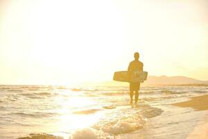 portret van een jong kitsurfen Mens Bij strand Aan zonsondergang foto