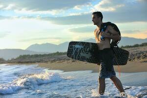 portret van een jong kitsurfen Mens Bij strand Aan zonsondergang foto