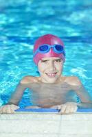 gelukkig kind Aan zwemmen zwembad foto