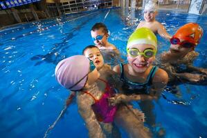 .Vrolijk momenten Bij zwemmen zwembad met grijnzend kinderen foto