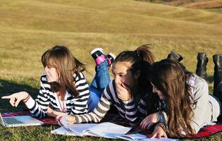 groep van tieners werken Aan laptop buitenshuis foto