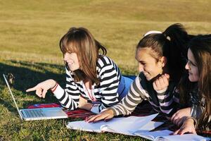 groep van tieners werken Aan laptop buitenshuis foto