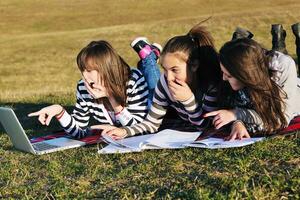 groep van tieners werken Aan laptop buitenshuis foto