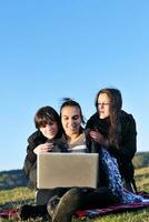 groep van tieners werken Aan laptop buitenshuis foto