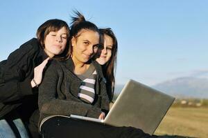 groep van tieners werken Aan laptop buitenshuis foto