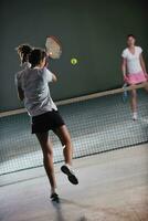 jong meisjes spelen tennis spel binnen- foto