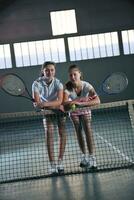 jong meisjes spelen tennis spel binnen- foto