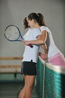 jong meisjes spelen tennis spel binnen- foto