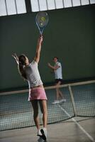 jong meisjes spelen tennis spel binnen- foto