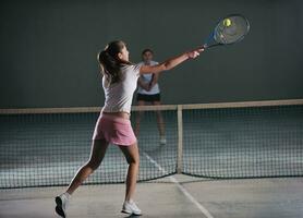 jong meisjes spelen tennis spel binnen- foto