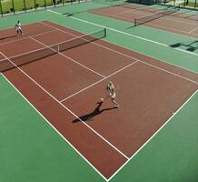 gelukkig jong paar Speel tennis spel buitenshuis foto