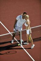 gelukkig jong paar Speel tennis spel buitenshuis foto