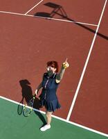 jonge vrouw speelt tennisspel buiten foto
