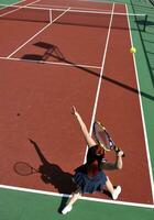 jonge vrouw speelt tennisspel buiten foto